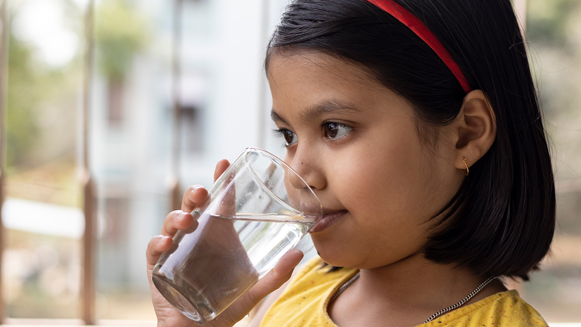 A child drinking a glass of water.