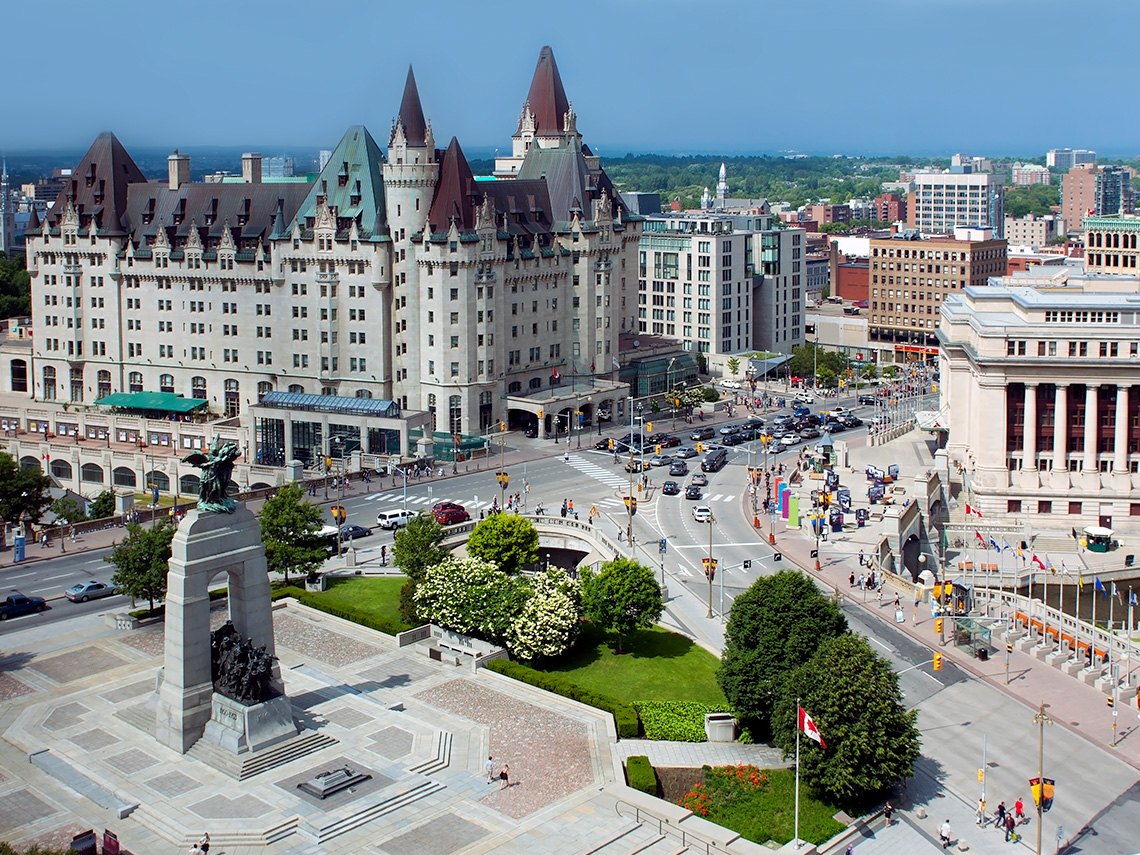 An image of Chateau Laurier in Ottawa. There is a busy square and main street outside of it.
