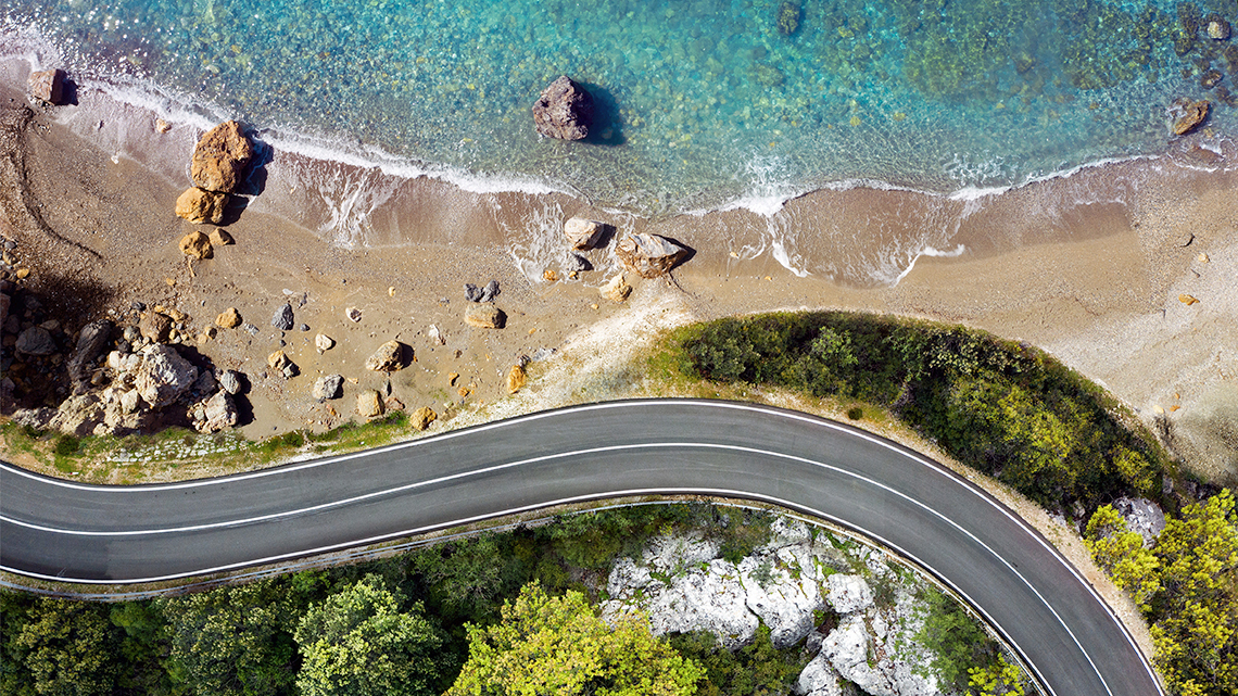 Aerial view of a road next to a coastline. 