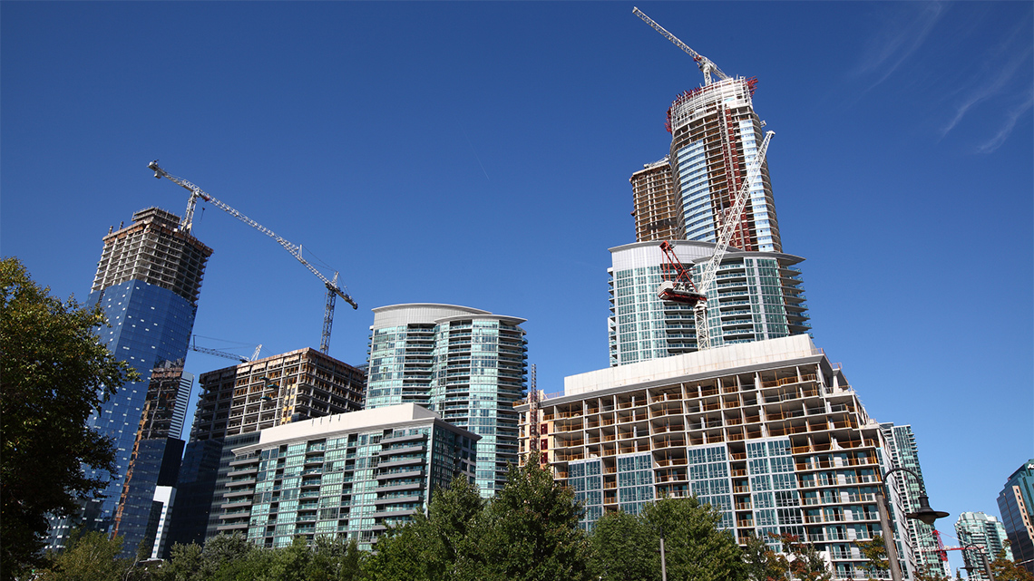 Multiple apartment buildings being constructed by cranes.