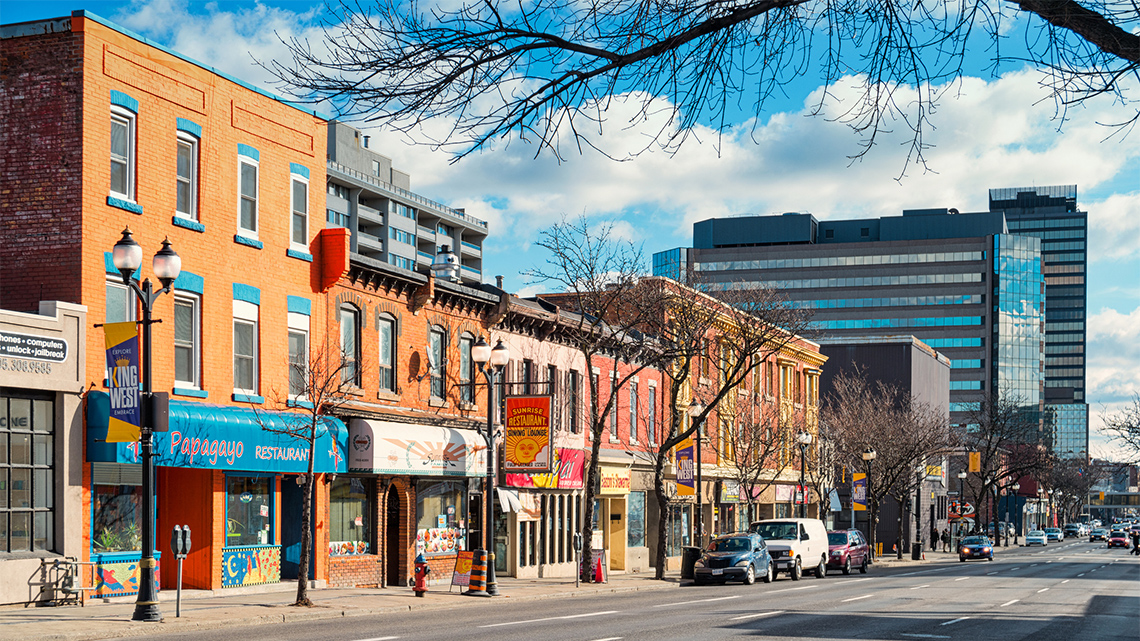Storefronts on a main street with an office building in the background.