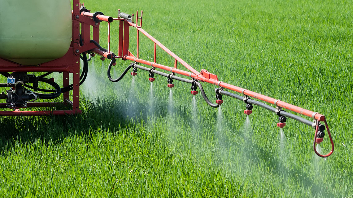 A tractor spraying over a field.