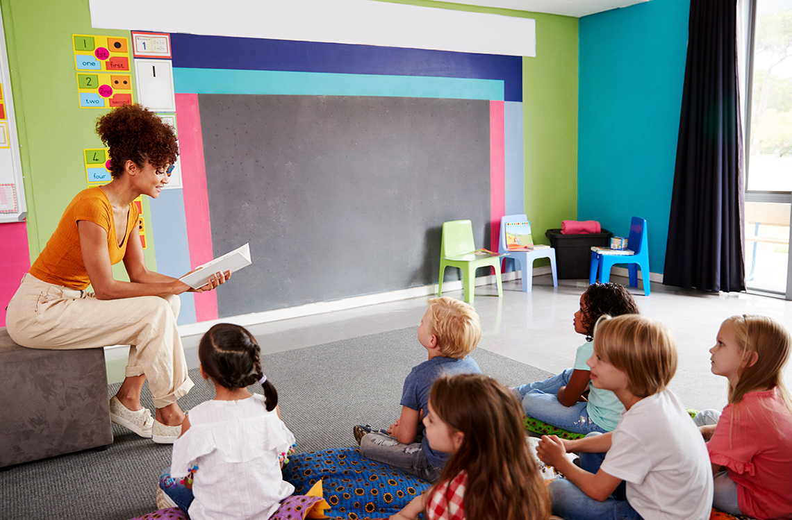 A teacher reads a story to young students.