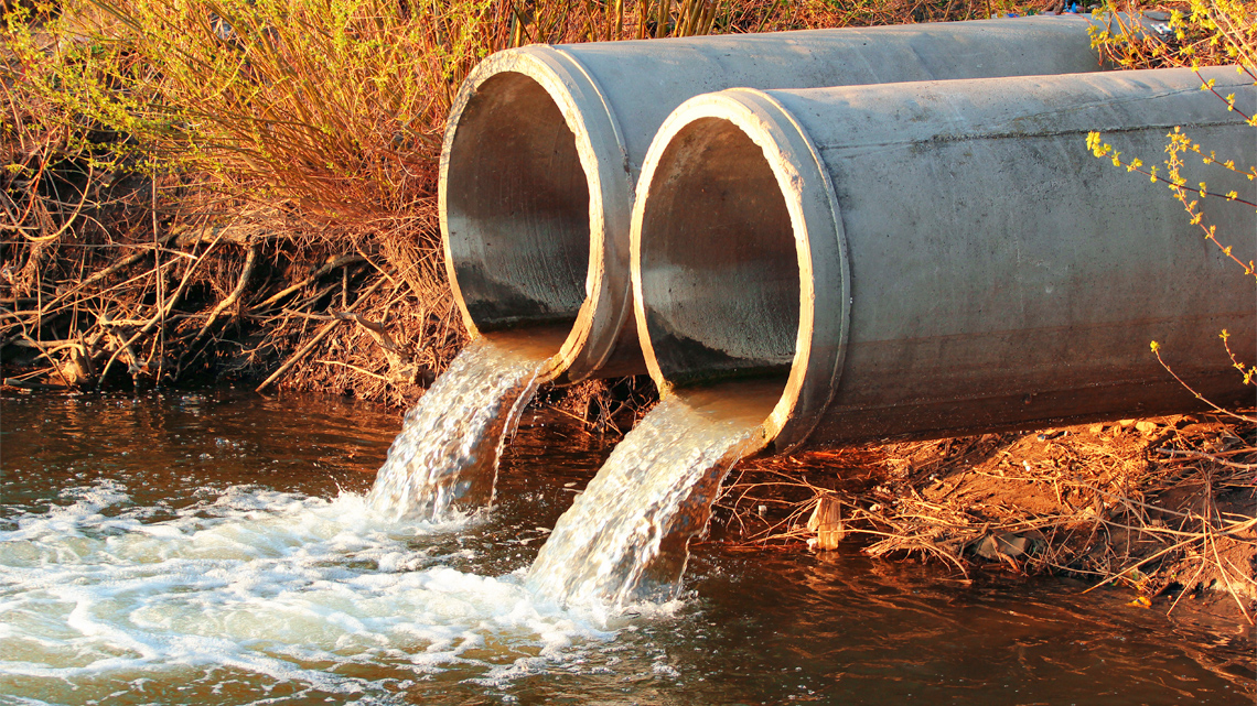 Sewage Pipes pouring water into a lake.