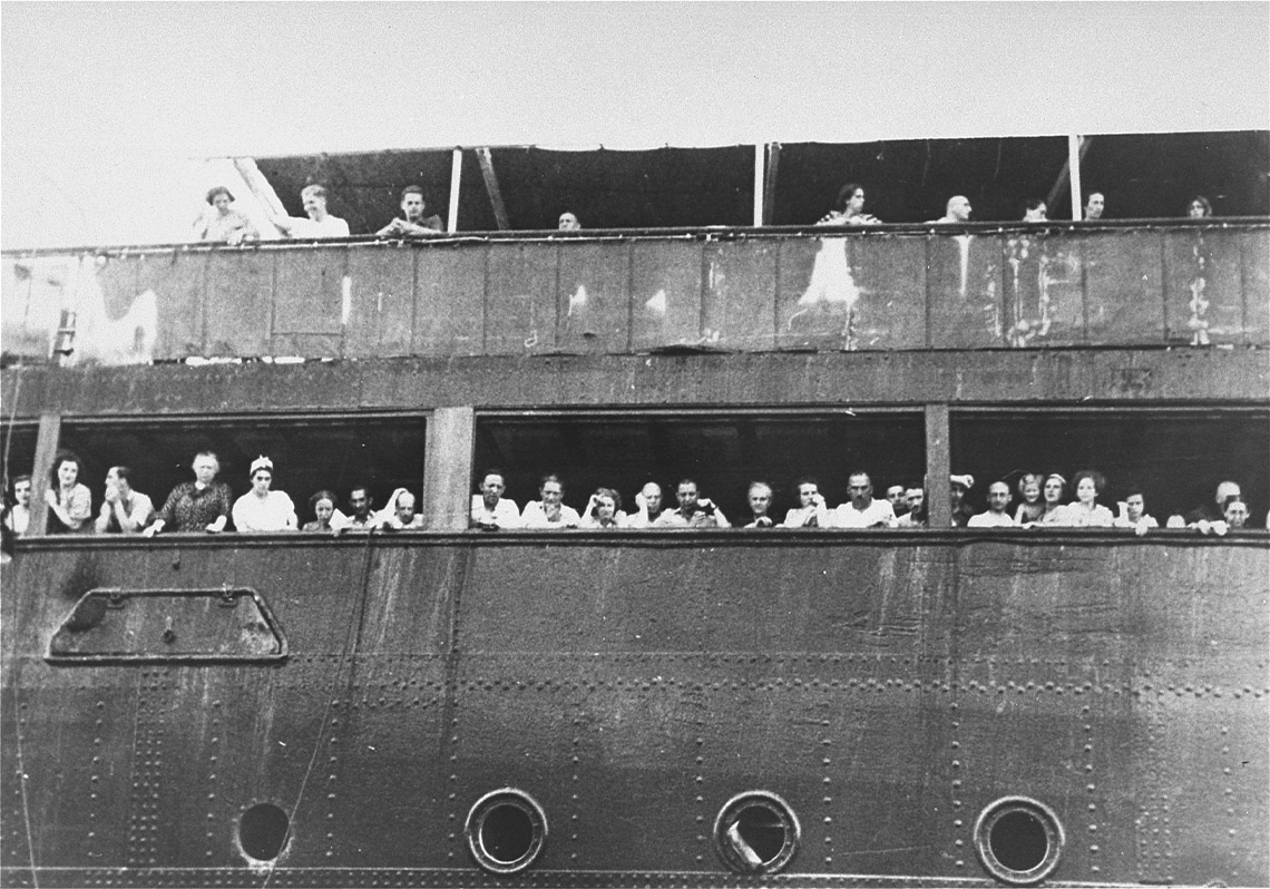 A large ship with many people looking out.
